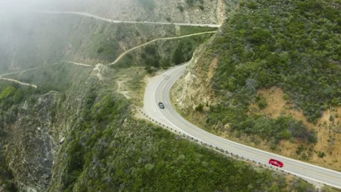 Traffic and trees off a cliff off the coast of the ocean Stock Footage 155462956