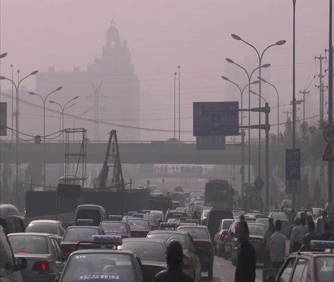 Traffic in Central Business District, shape of Regal Court Hotel seen in smog. Stock Footage 86743967