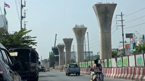 Traffic on the city road next to the construction of pillars Stock Footage 276153616