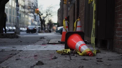 Traffic cone fallen over while cars drive by in background during sunet Stock-Footage 111345333