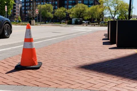 Traffic cone marks construction area along busy street in urban neighborhoo.. Foto stock