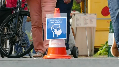 Traffic cone with sign Use face mask on a weekly market, mask requirement, Ge Stock Footage 139128065