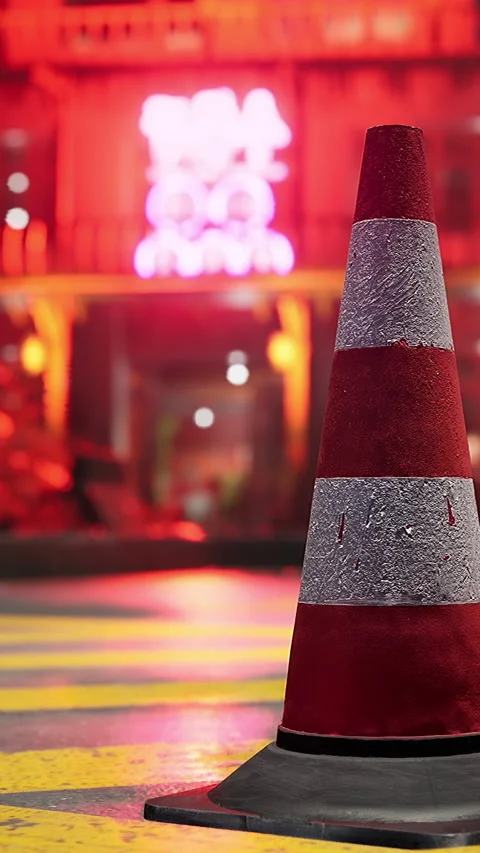 Traffic cone stands near yellow lines as city lights shine at night Stock Footage 340266026