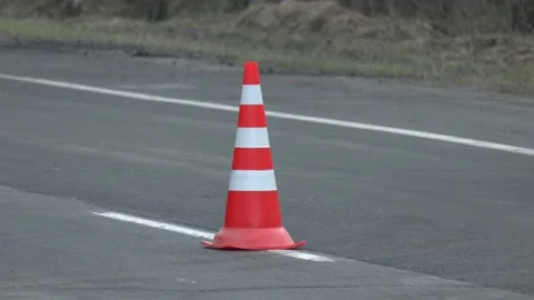 Traffic cone, with white and orange stripes on asphalt. Stock Footage 249923486