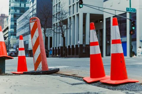 Traffic cones mark a construction site on a city street during the day as p.. Stock Photos