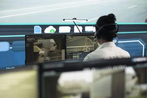 Traffic control operator wears headset while monitoring road and tunnels cameras Stock Photos