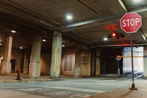 Traffic control at parking garage with stop sign and red light during night.. Stock Photos