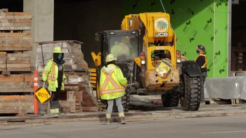 Traffic control persons directing construction vehicle on the street (variant). Видео 147995491