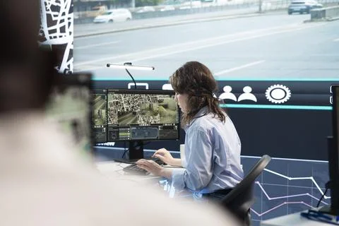 Traffic control room operator reviewing road camera feeds, typing on PC Stock Photos