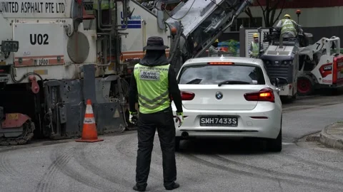 Traffic control worker  at junction in SIngapore. Road pavement works Stock Footage 208657228