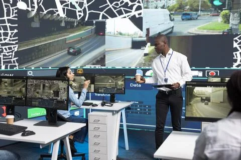 Traffic coordinator discussing with operator while holding coffee and tablet Stock Photos