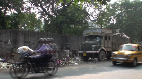 Traffic drives down a busy and dirty street in Calcutta Stock Footage 40005469