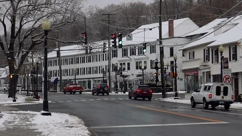 Traffic drives down a plowed main street on a snowy Winter morning in Bethel CT Stock Footage 120798520