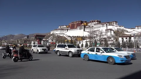 Traffic drives over busy intersection in front of Potala Palace in Lhasa Tibet Video stock 113046131