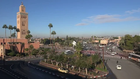 Traffic drives past Koutoubia mosque in central Marrakesh city, Morocco Stock Footage