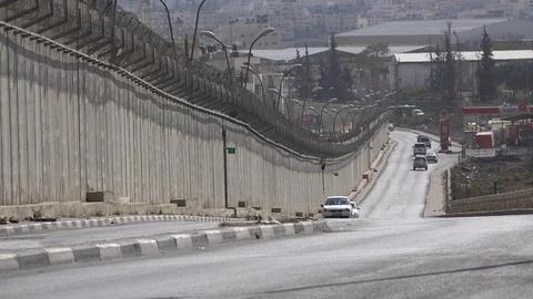 Traffic drives past the separation wall between Israel and the West Bank Video stock 71508739