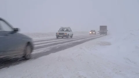 Traffic driving along freeway during intense snow storm Stock Footage 70722663