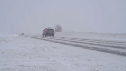 Traffic driving along freeway during intense snow storm Stock Footage 70722884