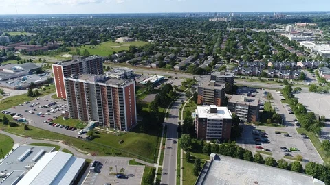 Traffic Driving Between Two Sets Of Apartment Buildings With Cityscape In Di Stock Footage 123010704