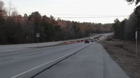 Traffic driving at high speeds through a Road construction site over a creek  Stock Footage 148959172