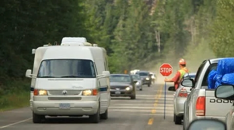 Traffic flagging person controls traffic Stock Footage 10751139