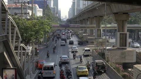 Traffic flowing through a busy road next to high metro line Bangkok, Thailand Stock Footage 85213340