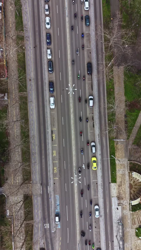 Traffic flows along a city road with cars and motorcycles moving in multiple Stock Footage 337907131