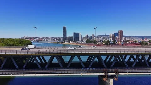 Traffic flows over a bridge with a city skyline in the background Vidéo 343126015