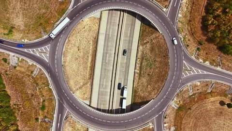 Traffic flows on a roundabout connecting multiple roadways in a rural area under Stock Footage 342726789