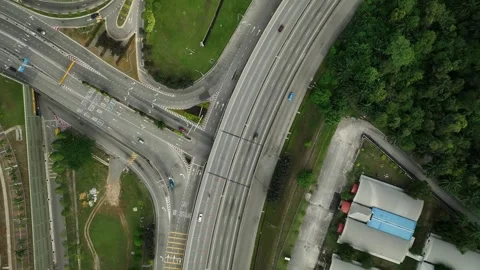 Traffic flows seamlessly at a busy intersection surrounded by greenery Stock Footage 311987410