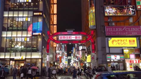 Traffic in front of the neon-lit arch of kabukicho ichibangai in Shinjuku. Stock-Footage 149437025