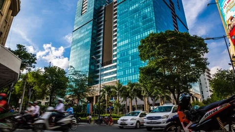 Traffic in front of an office tower and shopping mall in Ho Chi Minh City Видео 116857565