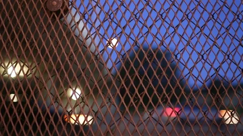 Traffic going by on a highway viewed through a chain link fence Stock Footage 250801563