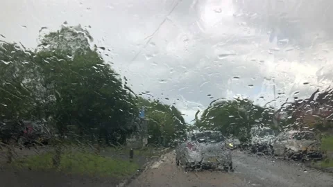 Traffic going past a parked car in the rain Stock Footage 154308524