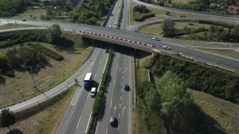 Traffic on highway with intersection and road signs near green areas in daytime  Stock Footage 335333792