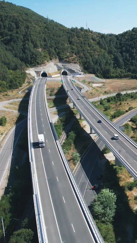 Traffic at highway roads surrounded by greenery viewed from above on a sunny  Stock-Footage 297435642