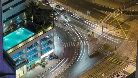 Traffic on intersection with tram at night timelapse from top, Dubai Marina Stock Photos