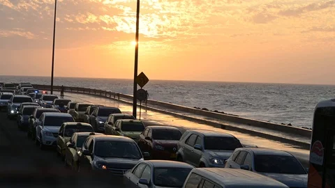 Traffic jam on a coastal road at sunset, sea wave crashing Vídeos de archivo 126548543