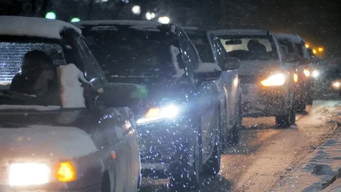 Traffic jam during snowy winter. Cars driving through epic snowfall at night Stock Footage 124737228