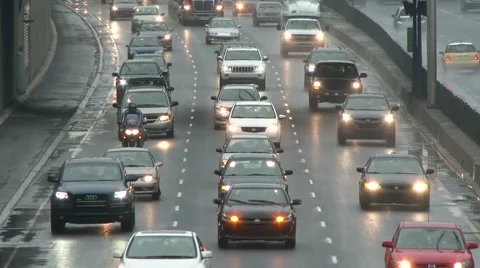 Traffic jam in rain with multiple cars and motorcycle driving slow on highway Stock Footage