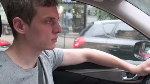 Traffic jam. Young attractive blond man sits at the wheel of a car Vídeo Stock 134540438