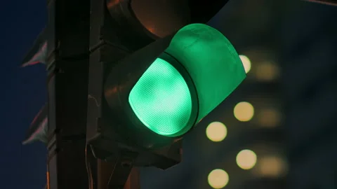 Traffic light against the background of the evening city flashes green and Stock-Footage 141597065