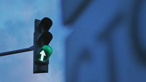 A traffic light on the background of a cloudy sky is lit in green. Arrow Stock Footage 141597135