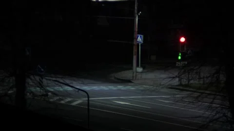 Traffic light blinks green and switches to red at a crosswalk at night, no Vídeos de archivo 256203853