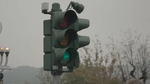 Traffic light changes color from green to yellow and then to red on a cloudy day Stock Footage 128055046