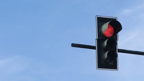 Traffic light changing from red to green against blue sky, Stock Footage 333308066
