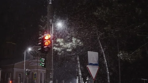 Traffic light in the city at the intersection in the winter night with snow Stock Footage 147356817