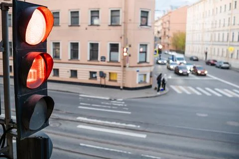 Traffic Light Controlling Intersection at Dusk With Cars Waiting and Pedest.. Stock Photos