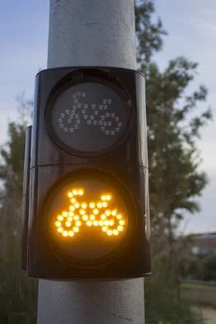 A traffic light for cyclists hangs on a pole Stock Photos