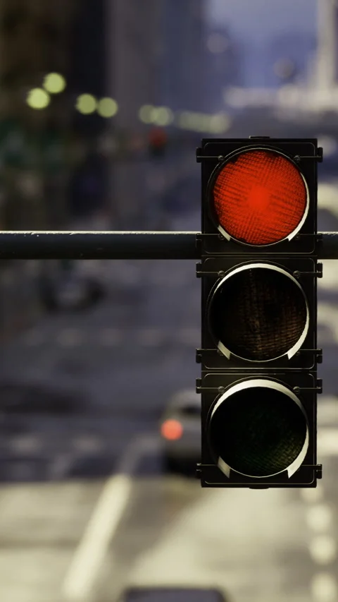 Traffic light displaying red in a busy downtown area during daylight hours 動画素材 313978597